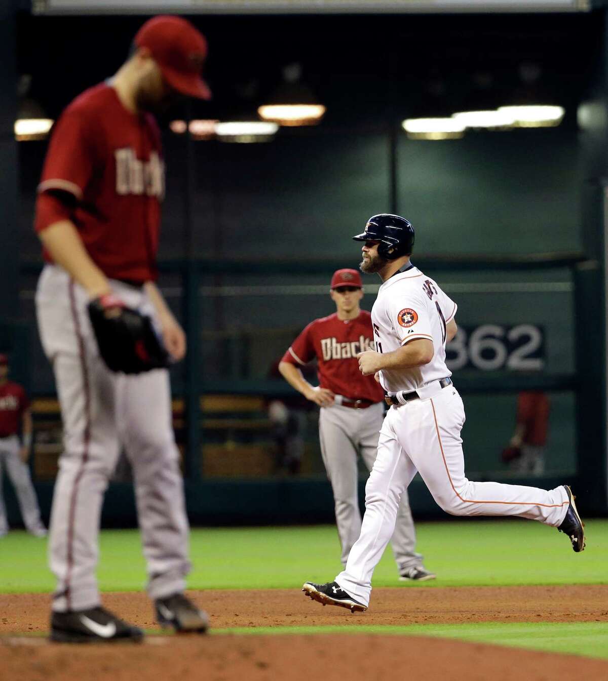 Houston Astros' Evan Gattis, right, runs the bases after hitting a home run off Arizona Diamondbacks starting pitcher Robbie Ray, left, during the fifth inning of a baseball game Sunday, Aug. 2, 2015, in Houston. (AP Photo/David J. Phillip)