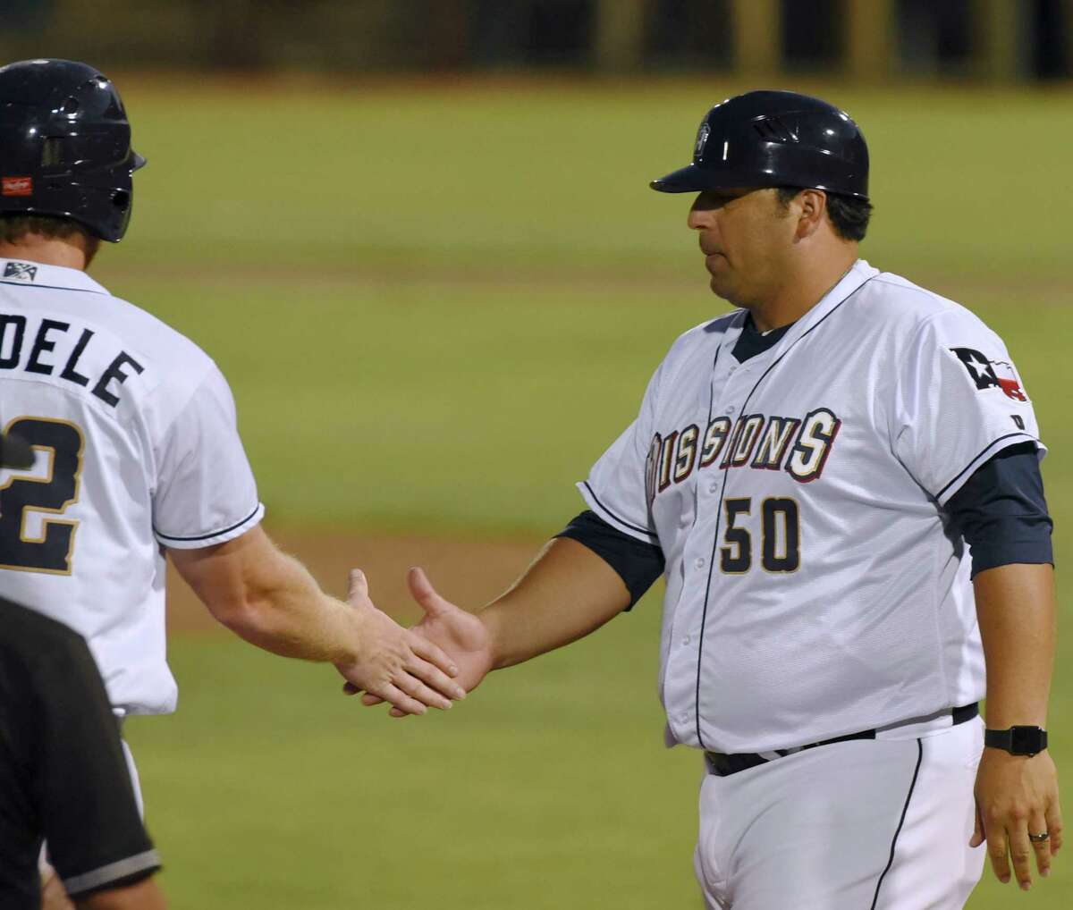 San Antonio Missions manager and third base coach Rod Barajas shakes hands with designated hitter Kyle Gaedele after Gaedele reached third base during Texas League action against Frisco at Wolff Stadium on Saturday, Aug. 1, 2015.