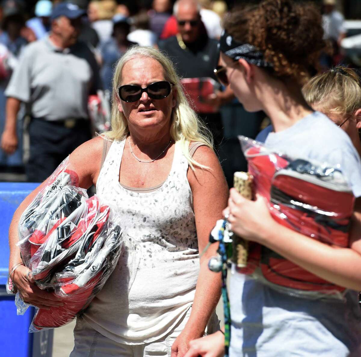 Racing patrons haul away arm loads of cooler bags, the most recent giveaway of the Saratoga season Monday morning Aug. 3, 2015 at the Saratoga Race Course in Saratoga Springs, N.Y. (Skip Dickstein/Times Union)