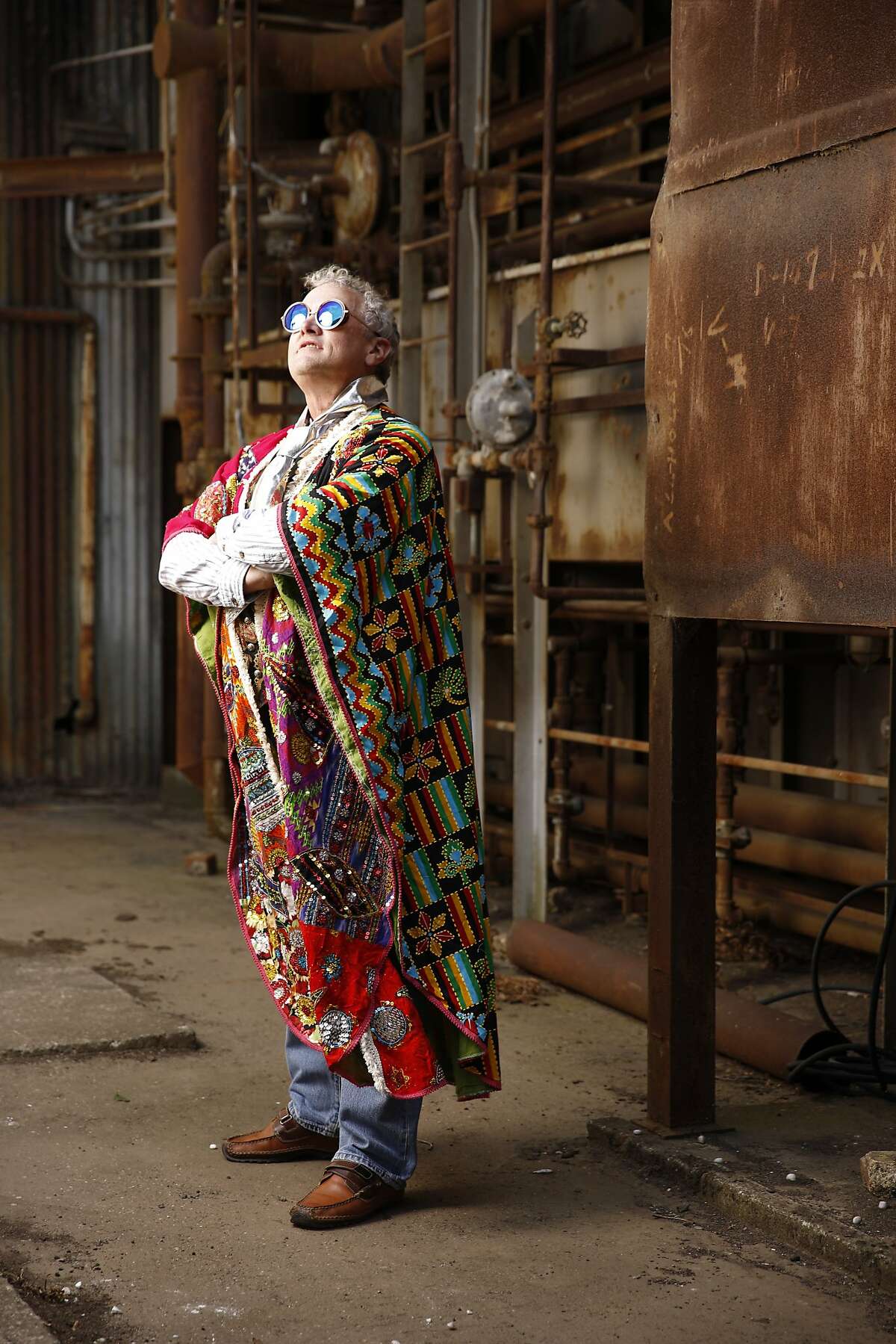 Eric Moeller, 60, a geologist from Inverness, will be attending his ninth Burning Man fest this year. On the playa, he goes by the name, "E," and says his playa style is "cool/kewl," and that it expresses "comfort." Because the festival features a carnival theme, he chose a bejeweled caftan from a designer called Ellko, and a metallic silver tie (not seen) and a vest (not seen) from Distractions on Haight Street. "for me it's about the carnival of mirrors. I'm wearing a tie that is made from a lady's belt, which doesn't need to be a lady's belt." Seen at a Burning Man costumes day-long dance party and Burning Man trunk show at Pier 70, site of an old shipyard now used as a public event space as seen in San Francisco, California, on Saturday, August 1, 2015.