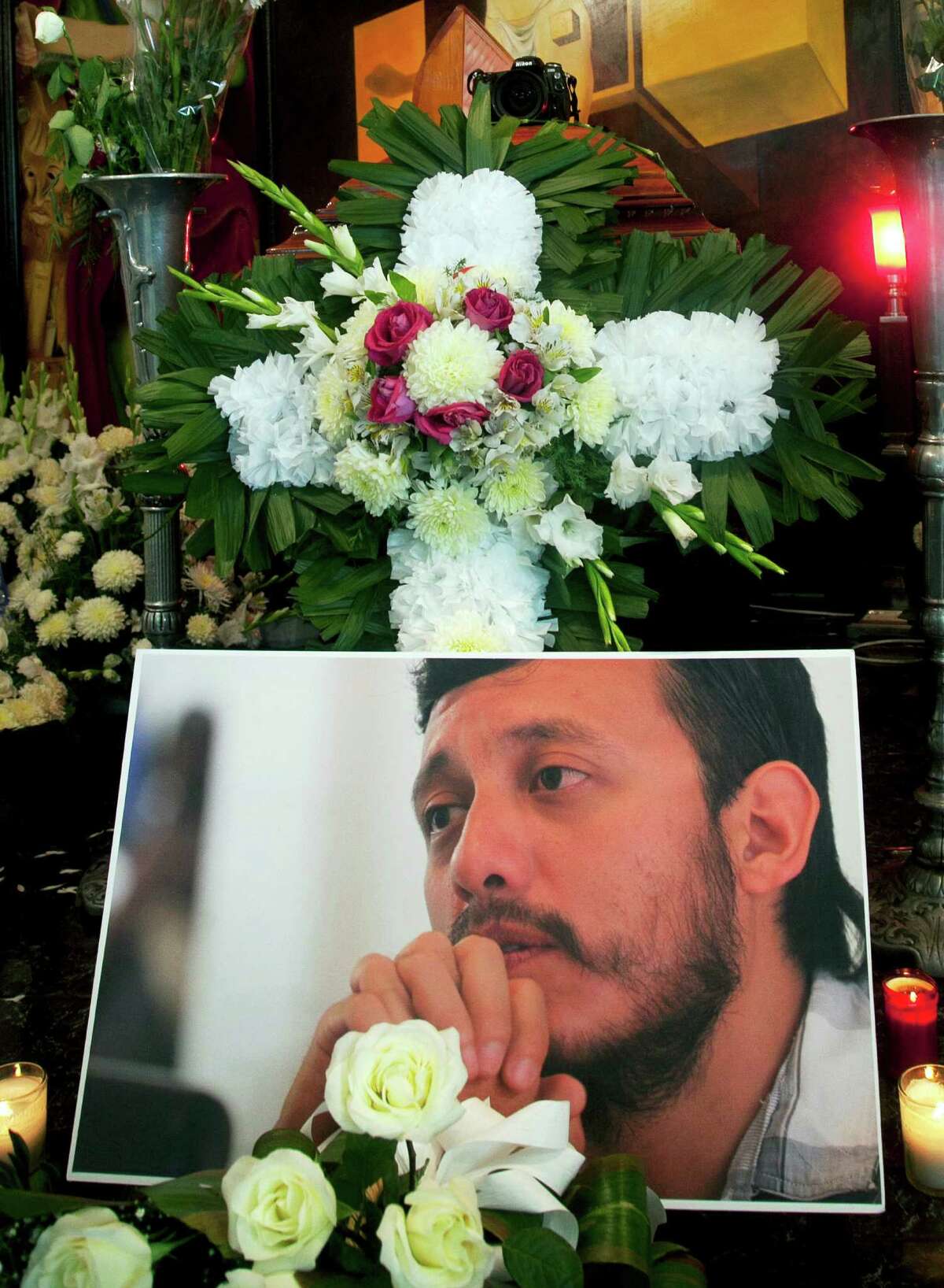 A photo of slain photojournal- ist Ruben Espinosa is in front of his casket in a funeral home in Mexico City.