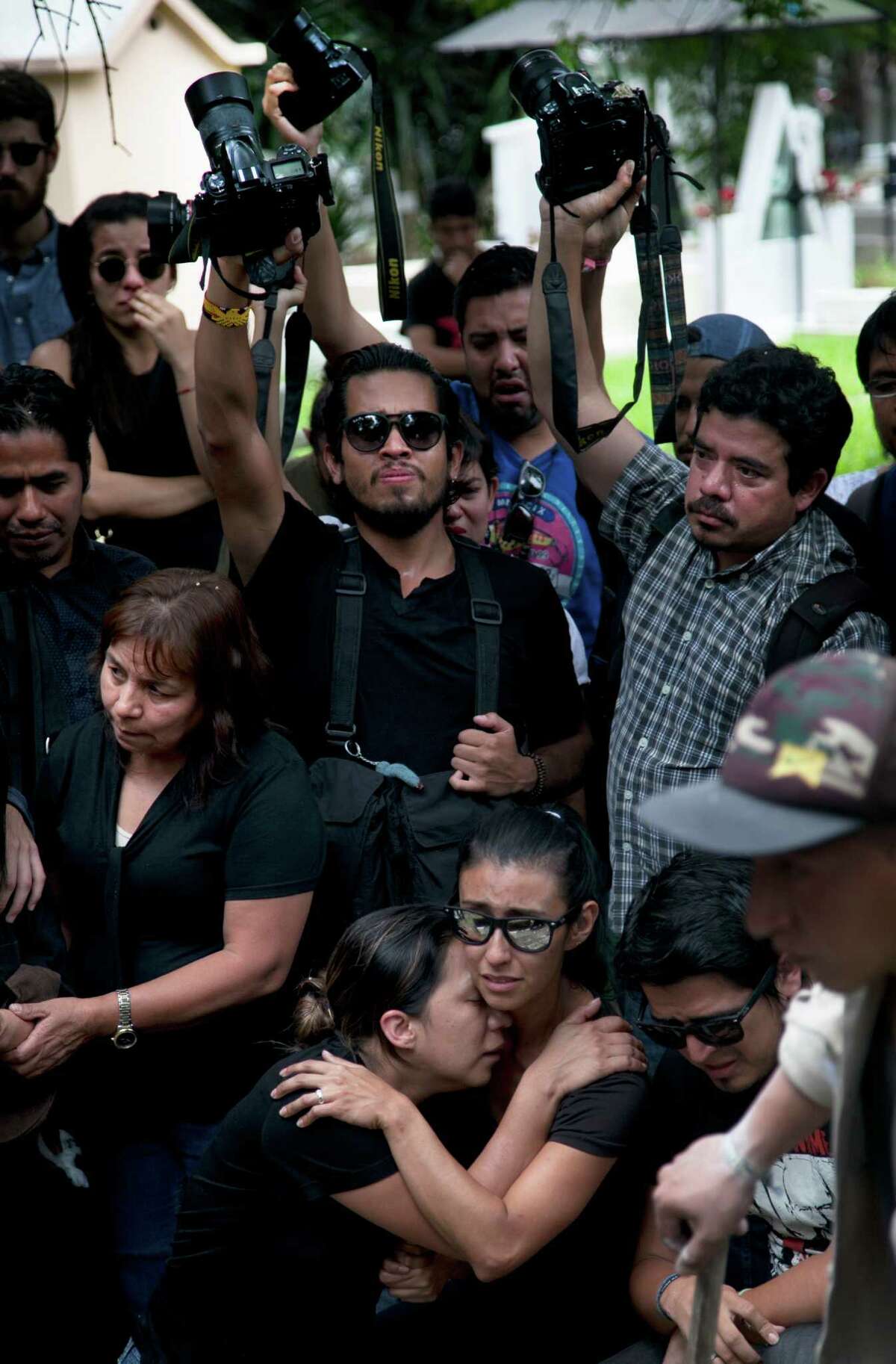 Family and friends mourn during the funeral of murdered photojournalist Ruben Espinosa in Mexico City, Monday, Aug. 3, 2015. With an investigation barely underway, Mexican journalist protection groups are already expressing fears that authorities won't consider Espinosa's brutal killing as being related to his work - even though he fled the state he covered fearing for his safety. Espinosa, 31, worked for the investigative magazine Proceso and other media in Veracruz state. (AP Photo/Marco Ugarte)