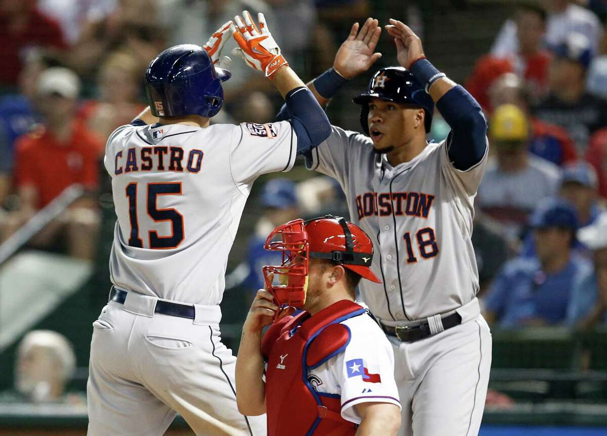 Catcher Jason Castro (15) is congratulated by Luis Valbuena after hitting a grand slam in the fourth inning of the Astros' 12-9 loss to the Rangers on Monday.