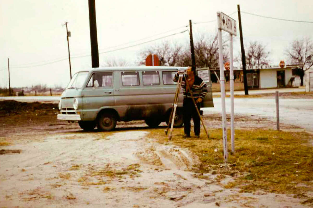 A Pape-Dawson Engineers employee surveys a property in a photo of the company's early days.