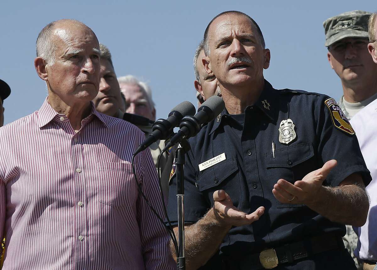 Cal Fire Chief Ken Pimlott, right, speaks next to Gov. Jerry Brown at a news conference at Cowboy Camp Trailhead near Clearlake, Calif., Thursday, Aug. 6, 2015. Crews backed by important firefighting resources are gaining ground against a massive Northern California wildfire, but it may be several days before thousands of evacuees can return home, officials said Thursday. (AP Photo/Jeff Chiu)