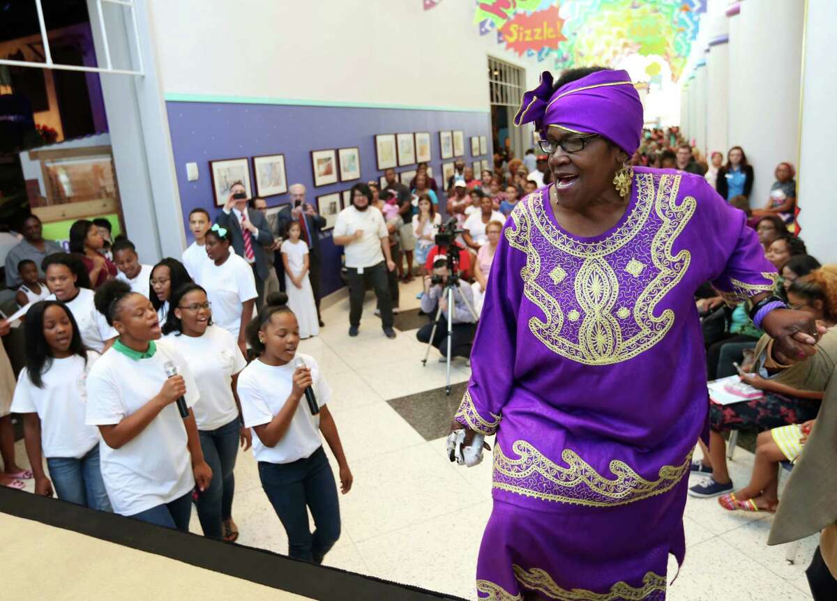Civil rights activist, Mamie King-Chalmers takes the stage while singing "We Shall Overcome," followed by members of the Community of Faith Youth Choir, at the Children's Museum of Houston Thursday, Aug. 6, 2015, in Houston. The Honey Brown Hope Foundation in partnership with Children's Museum of Houston presented "History Talks" featuring Mamie King-Chalmers and her life's work.