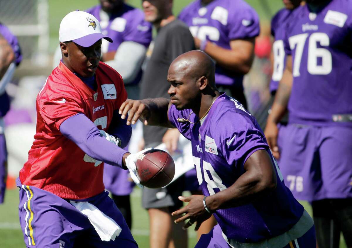 Minnesota Vikings quarterback Teddy Bridgewater hands the ball off to running back Adrian Peterson during practice at an NFL football training camp on the campus of Minnesota State University Wednesday, July 29, 2015, in Mankato, Minn. (AP Photo/Charles Rex Arbogast)