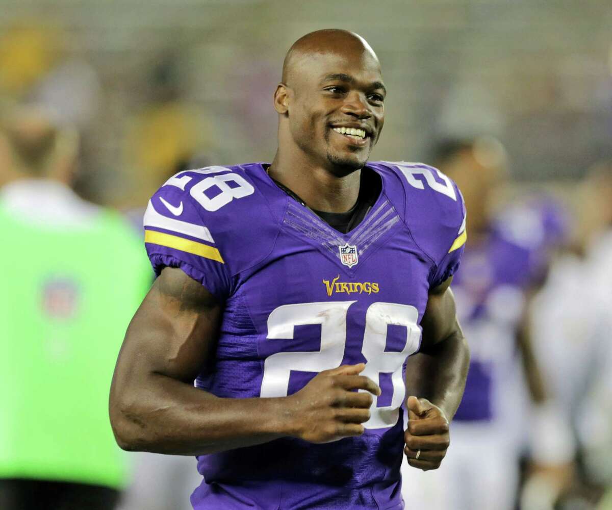 FILE - In this Aug. 8, 2014, file photo, Minnesota Vikings running back Adrian Peterson leaves the field after an NFL preseason football game against the Oakland Raiders in Minneapolis. The NFL has reinstated Minnesota Vikings running back Adrian Peterson, clearing the way for him to return after missing most of last season while facing child abuse charges in Texas. The league announced its decision on Thursday, April 16, 2015. (AP Photo/Jim Mone, File)