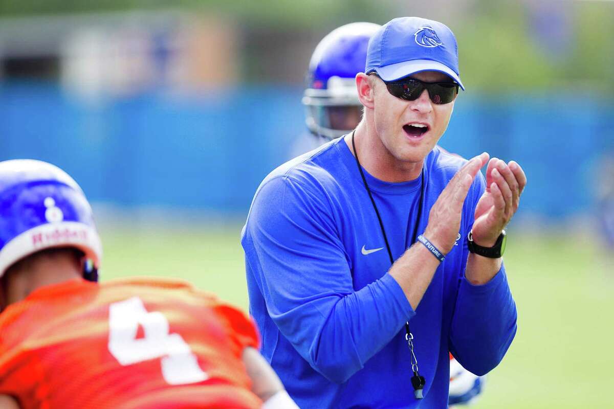 Boise State football head football coach Bryan Harsin cheers on his team during the first day of practice on the new DeChevrieux Field on the Campus of BSU. Friday Aug. 1, 2014.
