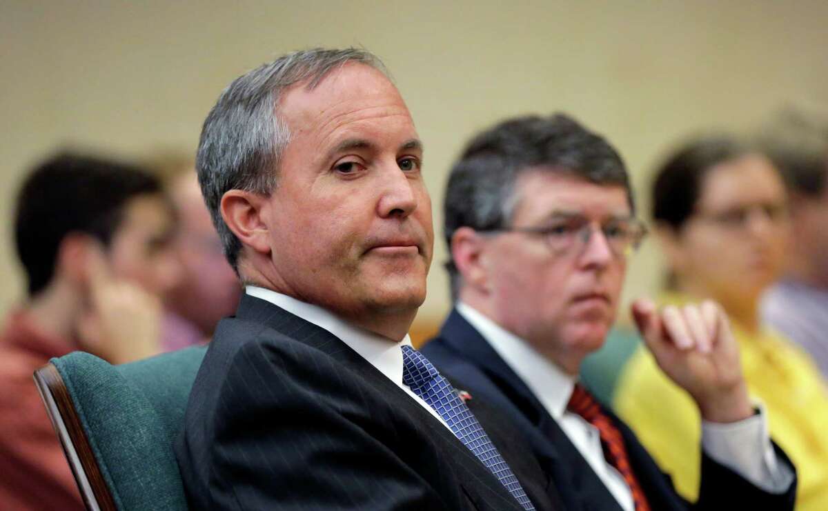 Attorney General Ken Paxton (left), seen on July 29, 2015, in Austin, is among Texas officials who have bent the rules to hire at least 146 people with personal or political connections, state records show.