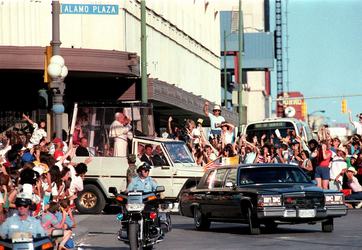 Pope John Paul II waves to a crowd at the corner of Alamo Street and Commerce Street Sept. 13, 1987, during his visit San Antonio.