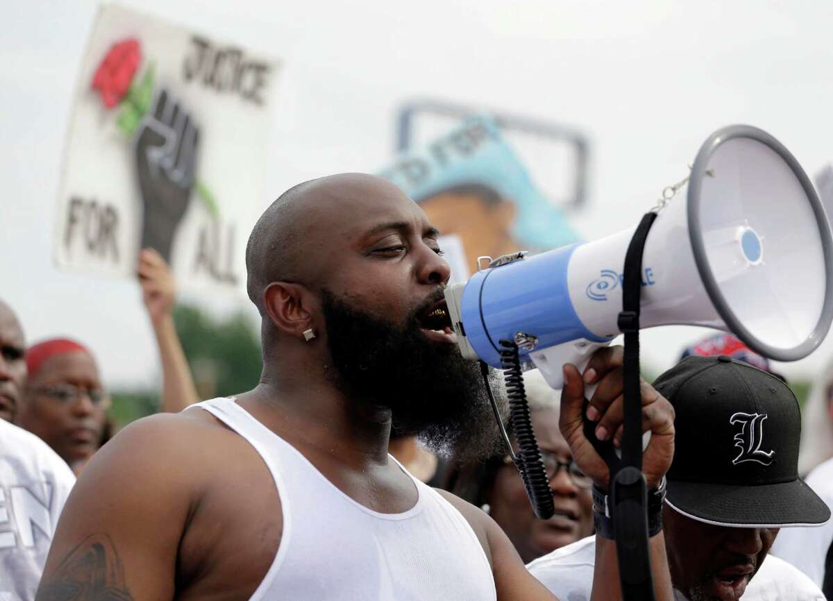 Michael Brown Sr. speaks through a megaphone as he takes part in a parade in honor of his son, Michael Brown, Saturday, Aug. 8, 2015, in Ferguson, Mo. Sunday will mark one year since Michael Brown was shot and killed by Ferguson police officer Darren Wilson. (AP Photo/Jeff Roberson)