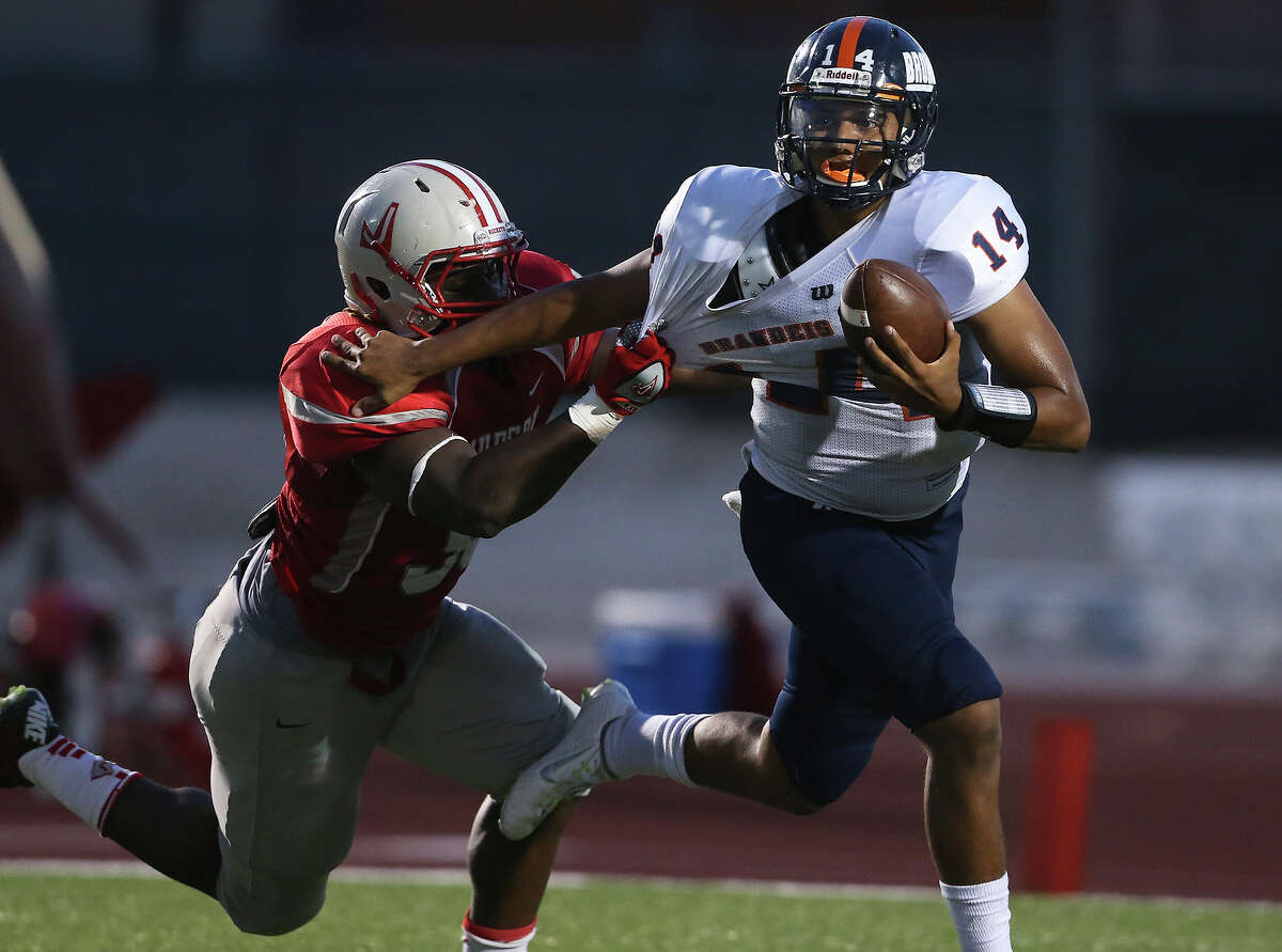 Brandeis quarterback Paul Loazona fights off a tackle by Judson’s Xavier Morris in his own end zone at Rutledge Stadium on September 5, 2014.