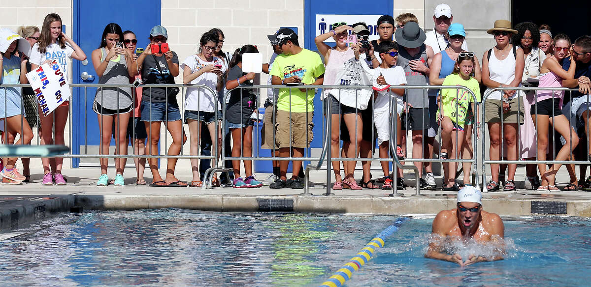 Swimming fans photograph Michael Phelps (bottom right) in the warmup pool prior to Phelps competing in the men's 100-meter butterfly during the 2015 Phillips 66 National Championships held Saturday Aug. 8, 2015 at the Northside Swim Center.
