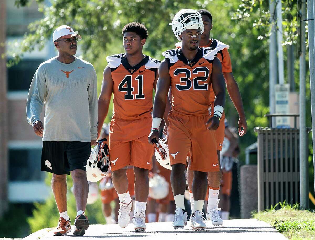 Texas defensive coordinator and secondary coach Vance Bedford, left, Tristian Houston (41), and Johnathan Gray walk to the first day of NCAA college football practice for the team, in Austin, Texas, on Friday, Aug. 7, 2015.