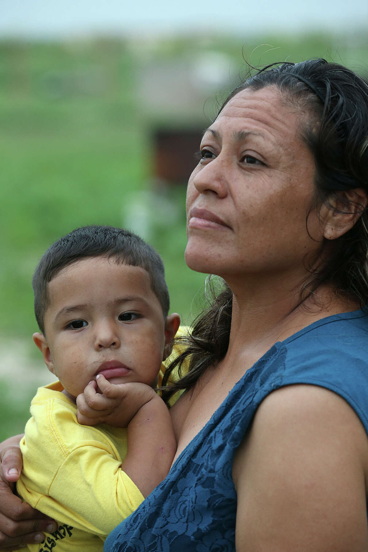 Rosie Rodriguez, 30, right, holds her son Adolfo, 2, as she talks of finally buying land in the Maize 5 colonia near Donna, Texas, Thursday, May 21, 2015. The one-street colonia is comprised of half-acre lots that cost $30,000. The lots come with electrical and water hook ups that drive the price up. A plot of land that sold for $5,000 a decade ago might be sold for as much as $30,000 today, leaving low income families with little money to invest quality materials to build their homes, leading to new developments the Fed has dubbed the "new colonias." Their owner financed plot of land comes at a steep price, almost 20-percent interest on a 20 year lone. Rodriguez and her family moved an old mobile home into their plot and are in the process of trying to fix it up.