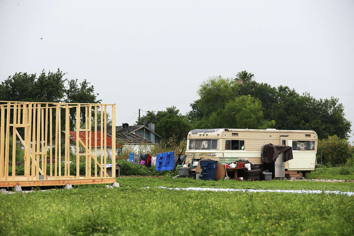 Construction continues on a small pier and beam house next to a older trailer home at Maiz 5, a "new colonia" near Donna﻿. The ﻿neighborhood's half-acre lots ﻿cost $30,000.﻿