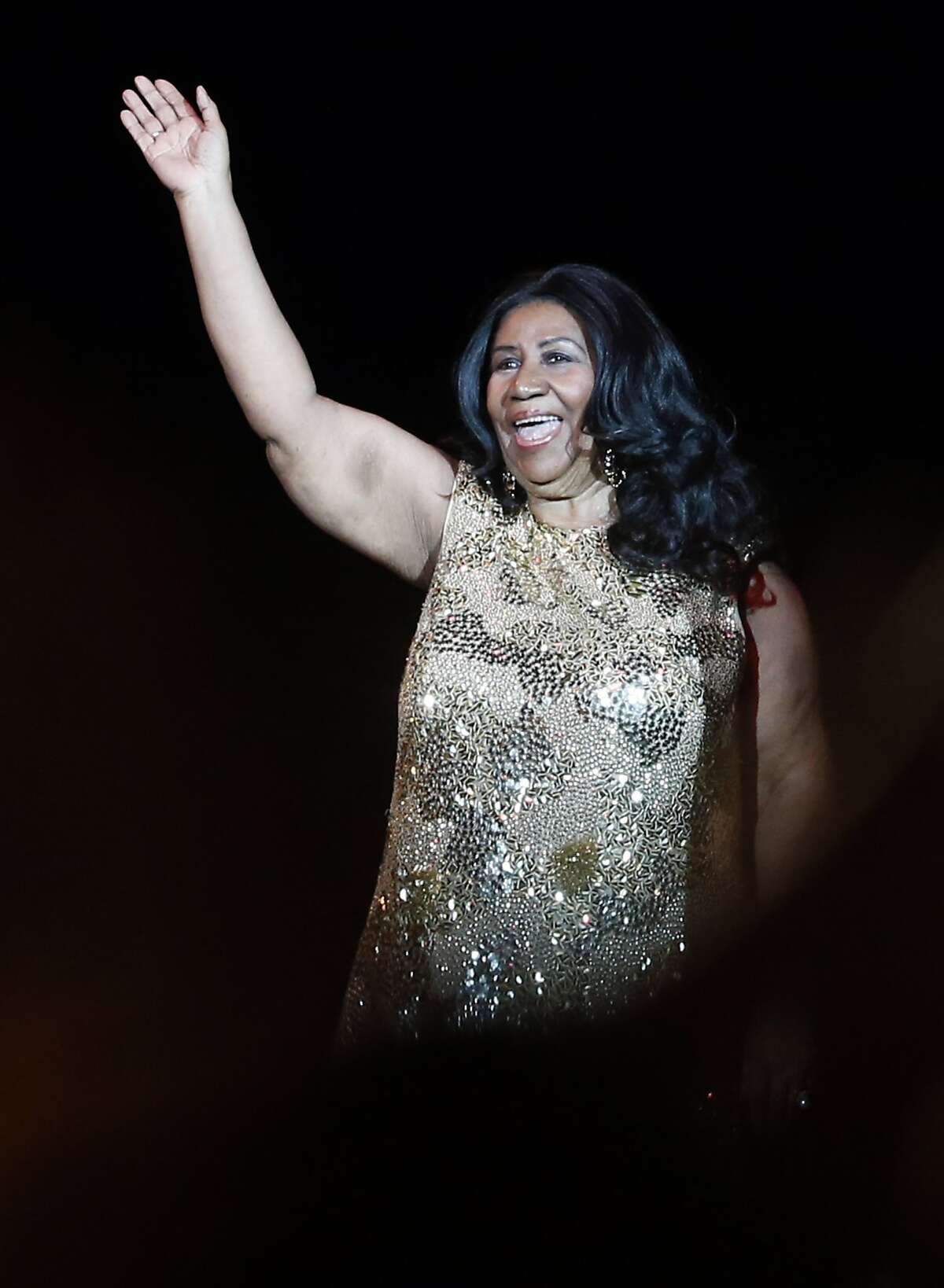Aretha Franklin acknowledges the crowd as she takes to the stage to perform at Oracle Arena in Oakland, Calif., on Monday, Aug. 10, 2015.