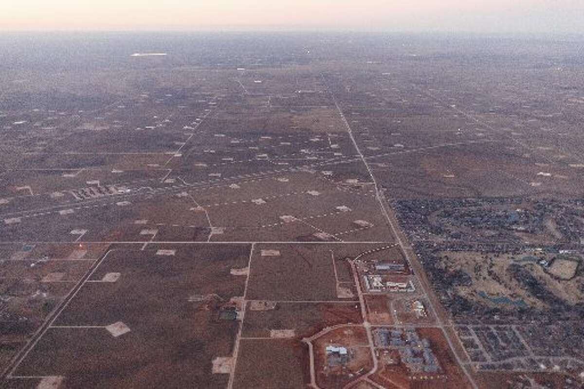 Oil well pads surrounding a development in Midland, Texas, Jan. 15, 2015. (Michael Stravato/The New York Times)