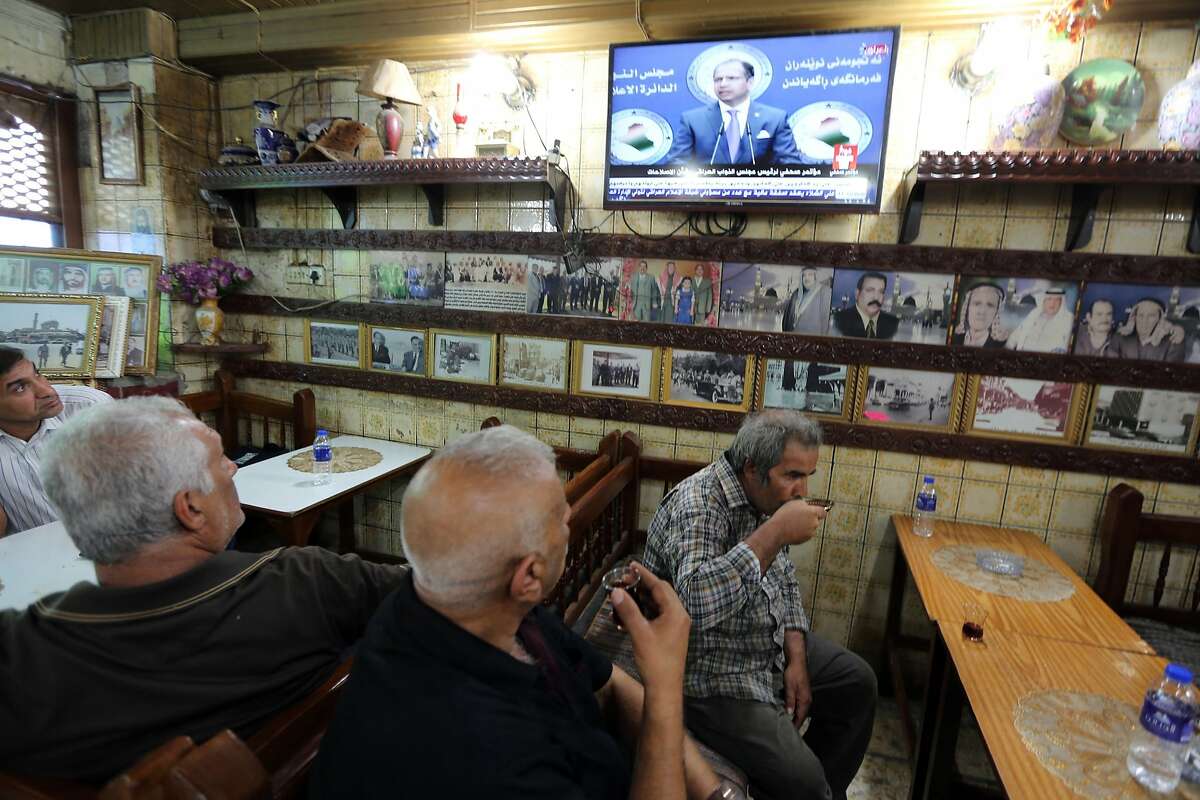 Iraqis watch at a cafe in the capital Baghdad on August 11, 2015, as Iraqi Parliament Speaker Salim al-Juburi delivers a televised statement after parliament unanimously approved Prime Minister Haider al-Abadi's reform programme aimed at curbing corruption.