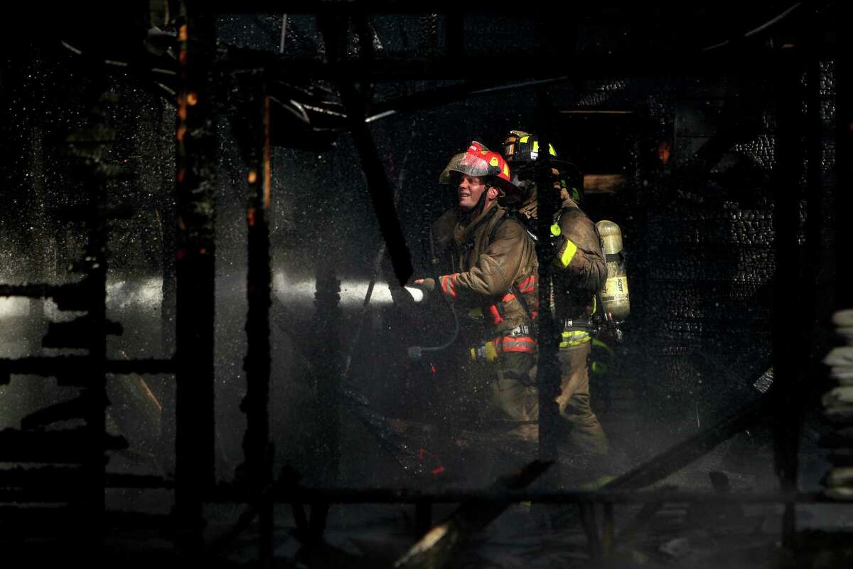 Captain Aaron Clark, of HFD Station #6, battles a house fire in the 2900 block of Sumpter St. near U.S 59 on Tuesday, Oct. 7, 2014, in Houston. No injuries were reported in the blaze, and investigators are trying to determine what sparked the fires. ( Mayra Beltran / Houston Chronicle )