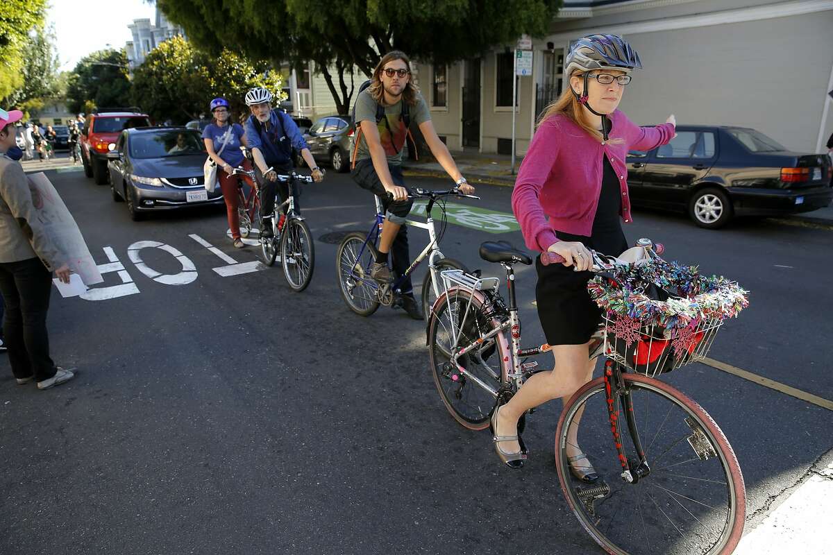 Sacha Ielmorini (right) executes a full stop at a stop sign during a biking protest on the way to a community meeting with SFPD Park Station Captain John Sanford in San Francisco, California, on Tuesday, Aug. 11, 2015.