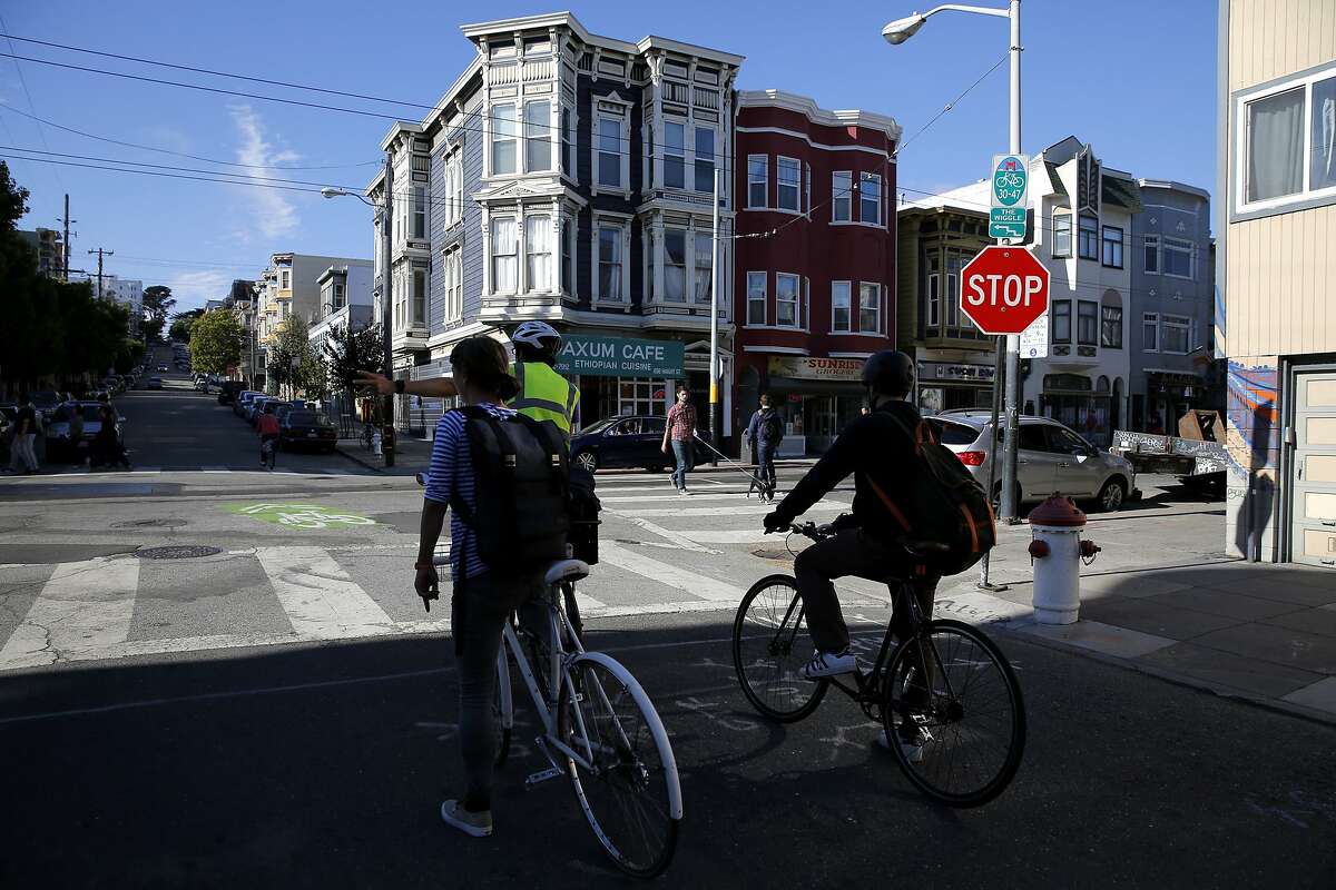 Bikers stop at an intersection on the Wiggle bike path in protest on the way to a community meeting with SFPD Park Station Captain John Sanford in San Francisco, California, on Tuesday, Aug. 11, 2015.
