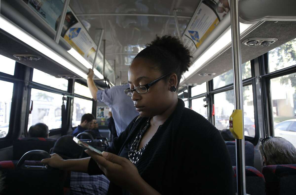Sarah Glover Johnson, of Oakland, uses the A/C Transit Wi-Fi service on her smartphone aboard a bus from Oakland to San Francisco, Calif., on Wed. August 12, 2015.