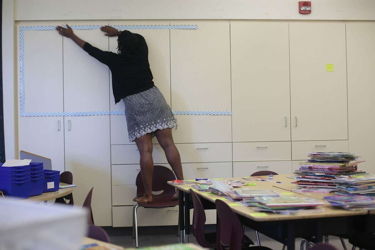 New SFUSD teacher Ashli Duncan sets up the border for her word board in her second grade classroom at Bessie Carmichael Elementary School on Wednesday, August 12, 2015 in San Francisco, Calif.