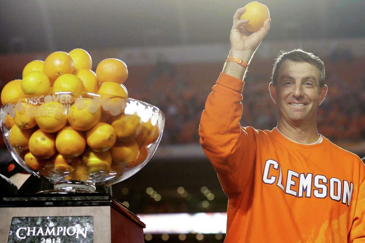 Clemson head coach Dabo Swinney throws oranges into the crowd as he celebrates after Clemson defeated Ohio State 40-3 in the Orange Bowl NCAA college football game, Saturday, Jan. 4, 2014, in Miami Gardens, Fla.