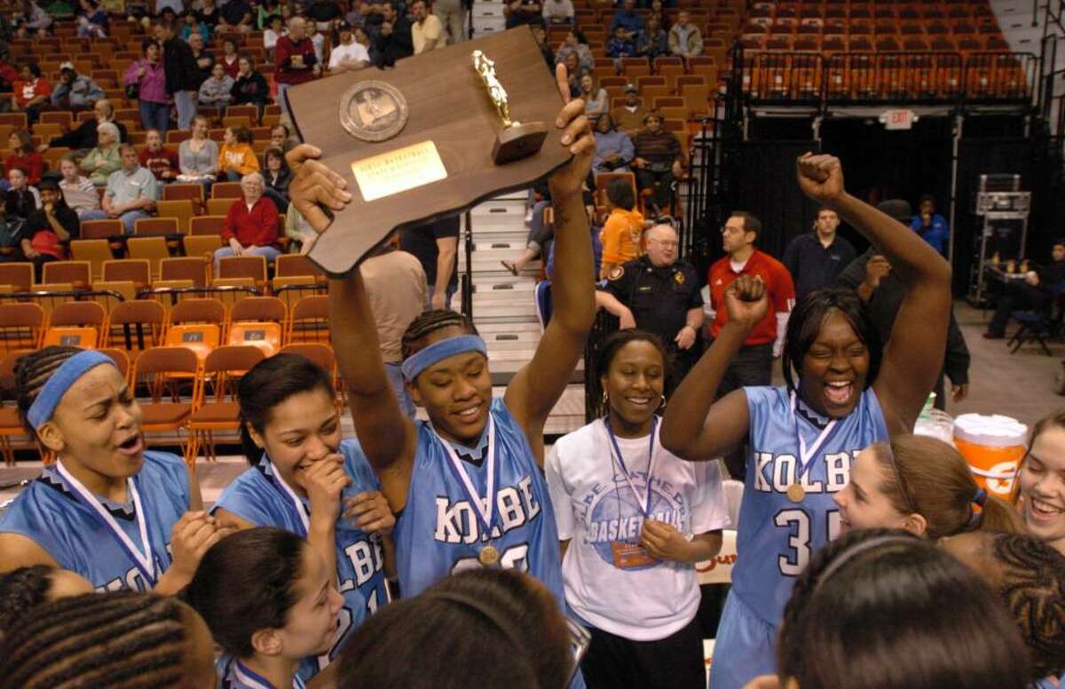 Kolbe's 23, Tiarrah Thompson, center, holds the championship plack after their team won the championship girls basketball game at Mohegan Sun, Friday, March 19, 2010.