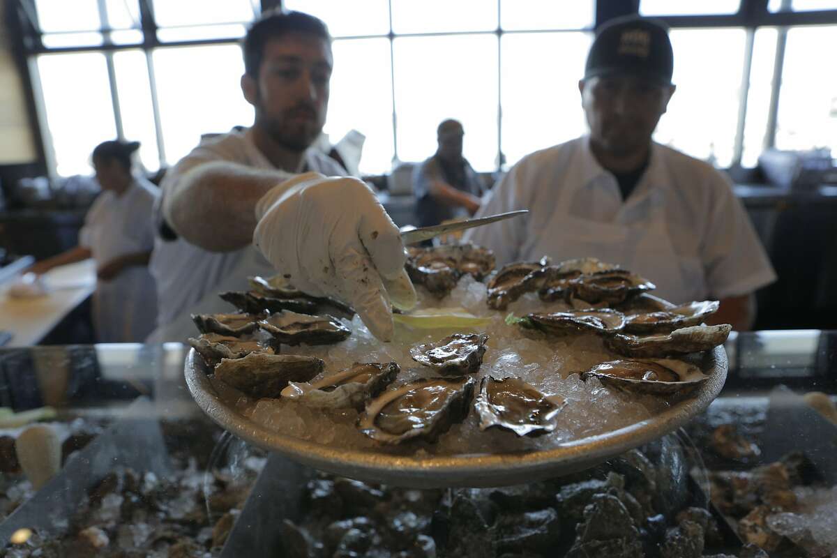 Oyster shuckers Ethan Thompson (left) and Koky Delgado work at Hog Island Oyster Company's restaurant at the Ferry Building Marketplace in San Francisco, Calif., on Thursday, July 16, 2015. Oysters are sent straight from aerated tanks in Marshall to the San Francisco restaurant most days.