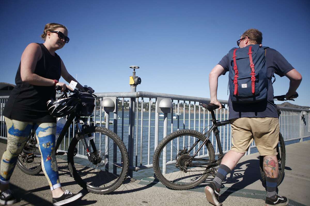 With the increase of tourist bikes, ferries are being backed up and struggling to keep up. Sarah Oliver, 26, and Mark Nalder, 25, make their way to board the Golden Gate Sausalito Ferry with their rental bikes on Thursday, Aug. 13, 2015.