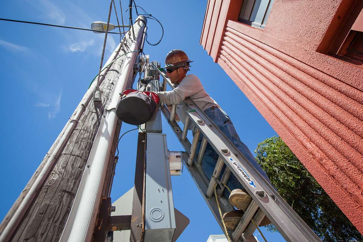 Brent Palmer, a contractor with Verizon Wireless, installs a remote radio unit (RRU) on a telephone pole in San Francisco, California, on Friday, Aug. 14, 2015. The RRU is a part of the cellular site that transmits the signal to the antenna.