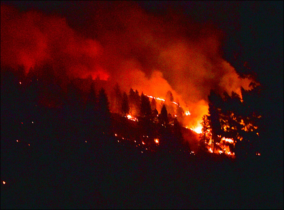 A massive wildfire burns the hillside Saturday morning, Aug 15, 2015, near Addy, Wash. Several fires in Stevens County stretched state and local fire forces thin overnight, driving some homeowners to battle the flames themselves.