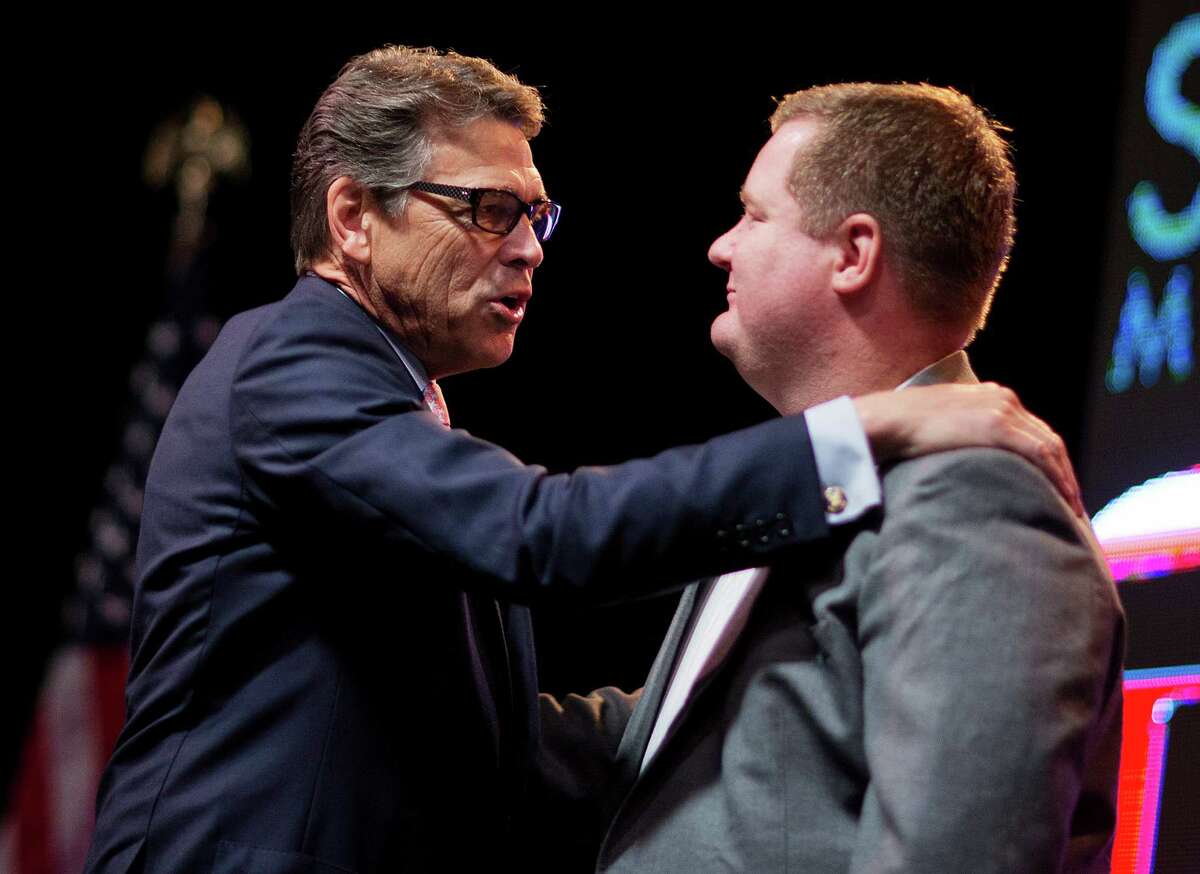 Republican presidential candidate and former Texas Gov. Rick Perry, left, embraces conservative blogger Erick Erickson as he speaks at the RedState Gathering Friday, Aug. 7, 2015, in Atlanta. (AP Photo/David Goldman)