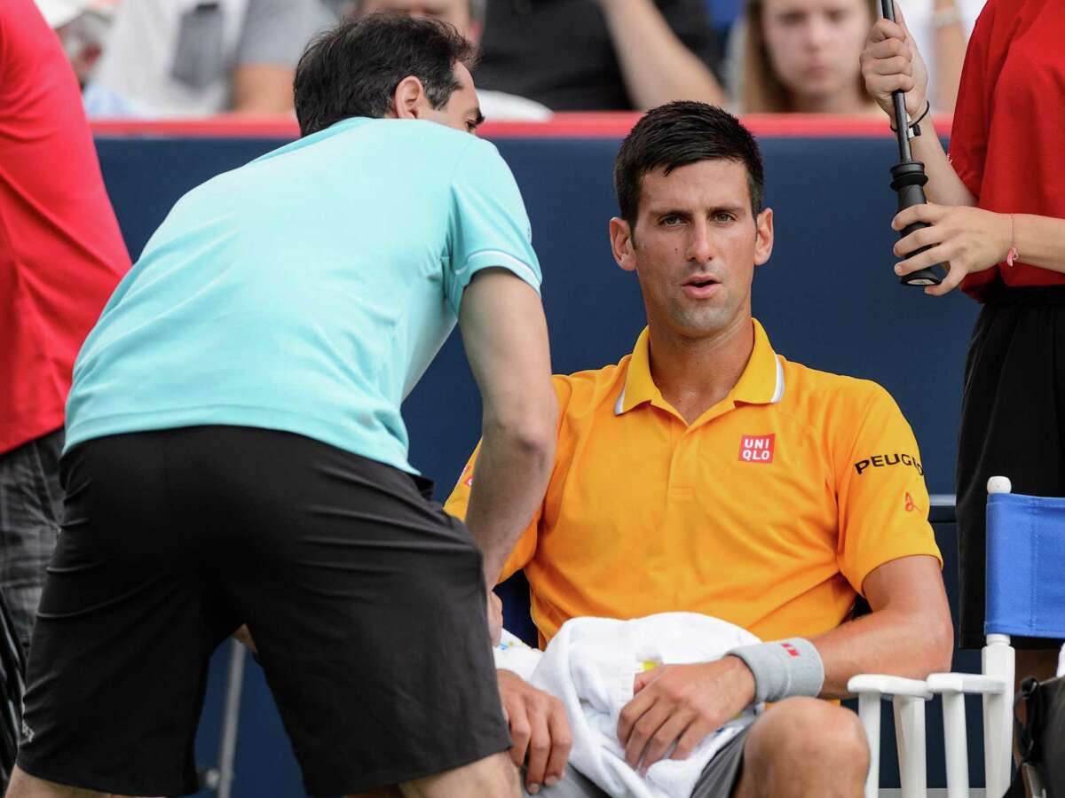 MONTREAL, ON - AUGUST 15: Novak Djokovic of Serbia is treated by medical staff in his match against Jeremy Chardy of France during day six of the Rogers Cup at Uniprix Stadium on August 15, 2015 in Montreal, Quebec, Canada. (Photo by Minas Panagiotakis/Getty Images) ORG XMIT: 559198859