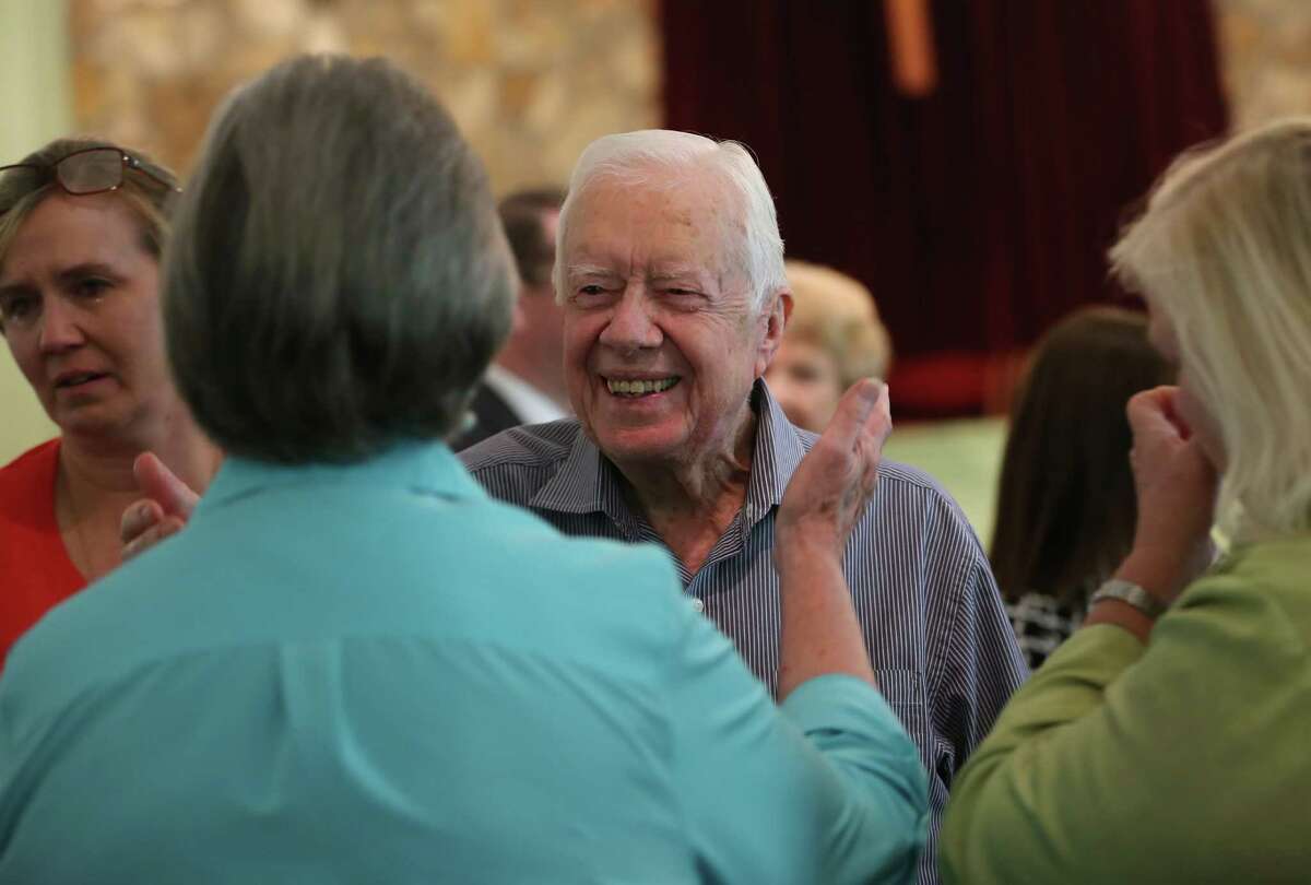 Former President Jimmy Carter reaches to embrace his brother Billy's widow Sybil while greeting family Sunday, Aug. 16, 2015, following service at Maranatha Baptist Church in Plains, Ga. Carter's nieces Mandy Flynn, left, and Jana Carter are also pictured. Sunday at church was emotional because it was the first time many members had seen Carter since his announcement that he has cancer. (Ben Gray/Atlanta Journal-Constitution via AP)