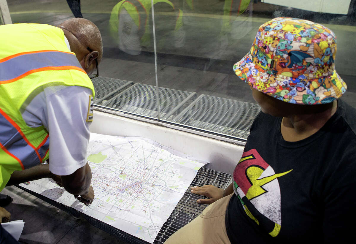 A Metro employee, left, helps Aneshia Remo at the Texas Medical Center Transit Center on Aug. 17.