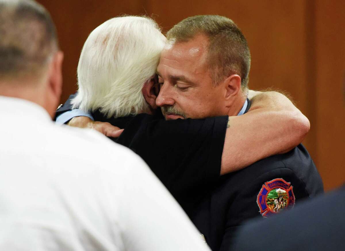 Dennis Frulla, right, gives his father Gary Frula, a retired firefighter, a hug after being sworn in as a Lieutenant during the Greenwich Fire Department promotional ceremony at Town Hall in Greenwich, Conn. Monday, Aug. 17, 2015. Frulla has 18 years of experience in the department currently as an instructor with expertise in heavy equipment and trucks.