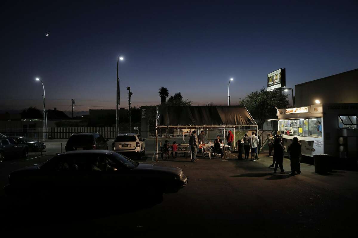 At twilight, customers order and eat at the Tacos Los Primos food truck in Richmond.