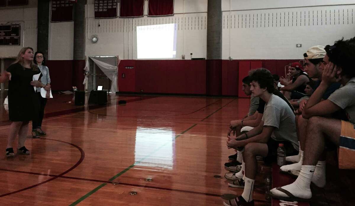 The YWCA’s Meredith Gold, left, and Yajaira Gonzalez give a presentation on domestic abuse and sexual assault to Greenwich High School football players in the high school’s gymnasium, on Wednesday, Aug. 19, 2015.