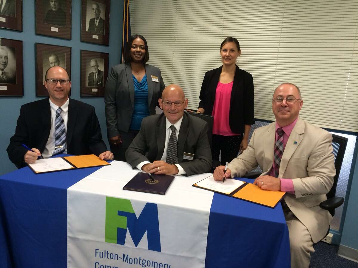 Flanked by staff from both institutions, Dr. Dustin Swanger, president, Fulton Montgomery Community College (far right), Dr. Patrick Jones, vice provost, Excelsior College (center), and Greg Truckenmiller, provost and vice president for academic affairs (far left), FMCC, sign a dual admission agreement at a ceremony in Johnstown, New York. (Submitted photo)