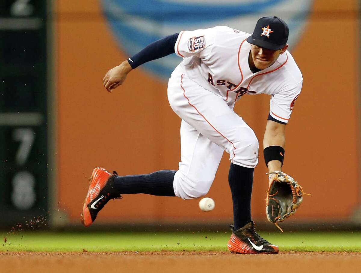 Houston Astros shortstop Carlos Correa (1) reaches for a ground ball hit by Tampa Bay Rays shortstop Asdrubal Cabrera (13) during the fourth inning of an MLB game at Minute Maid Park on Wednesday, Aug. 19, 2015, in Houston.