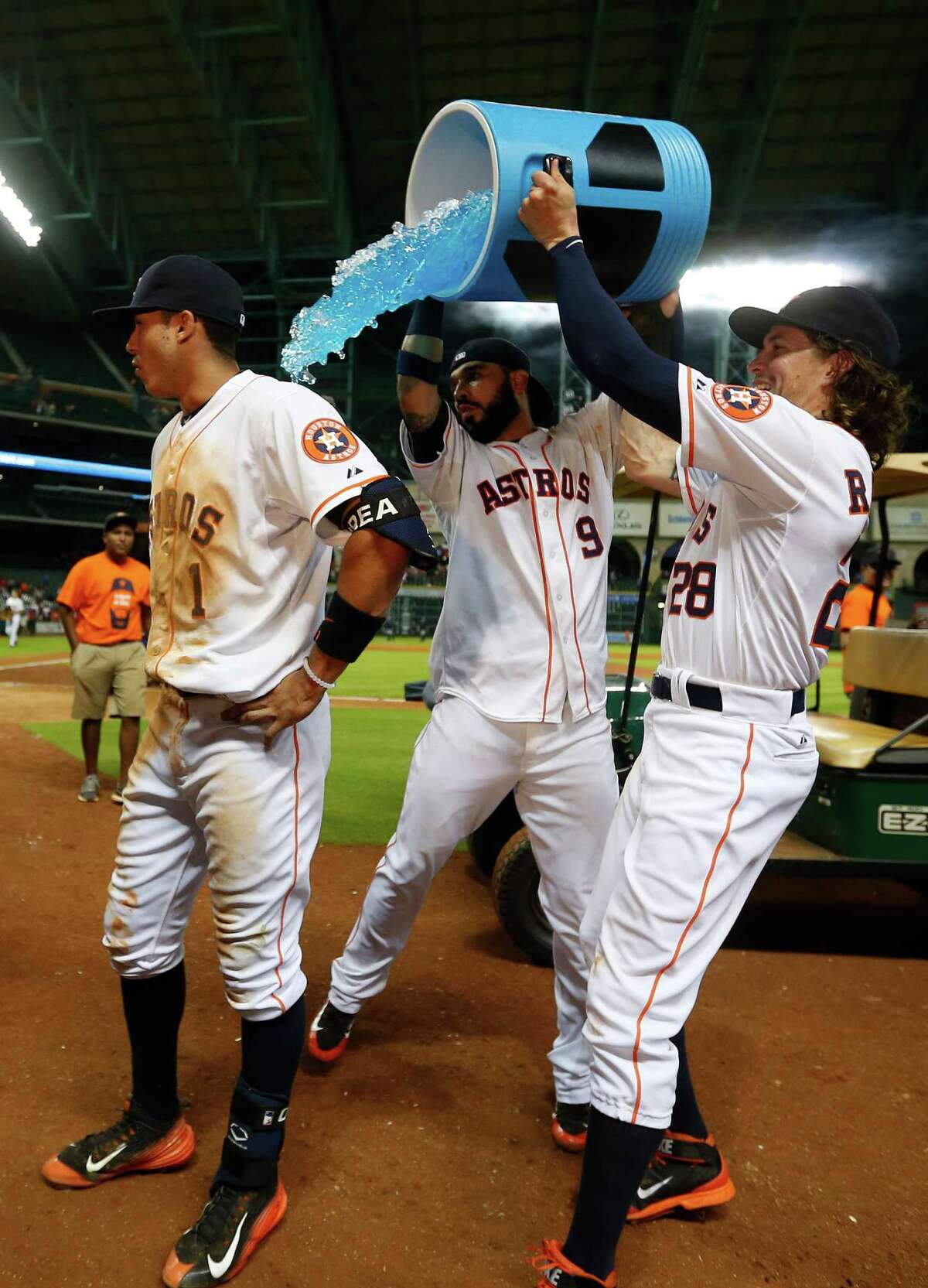 Houston Astros shortstop Carlos Correa (1) gets doused with Powerade by Marwin Gonzalez (9) and Colby Rasmus (28) after Correa's single scored the winning run during the thirteenth inning of an MLB game at Minute Maid Park on Wednesday, Aug. 19, 2015, in Houston.