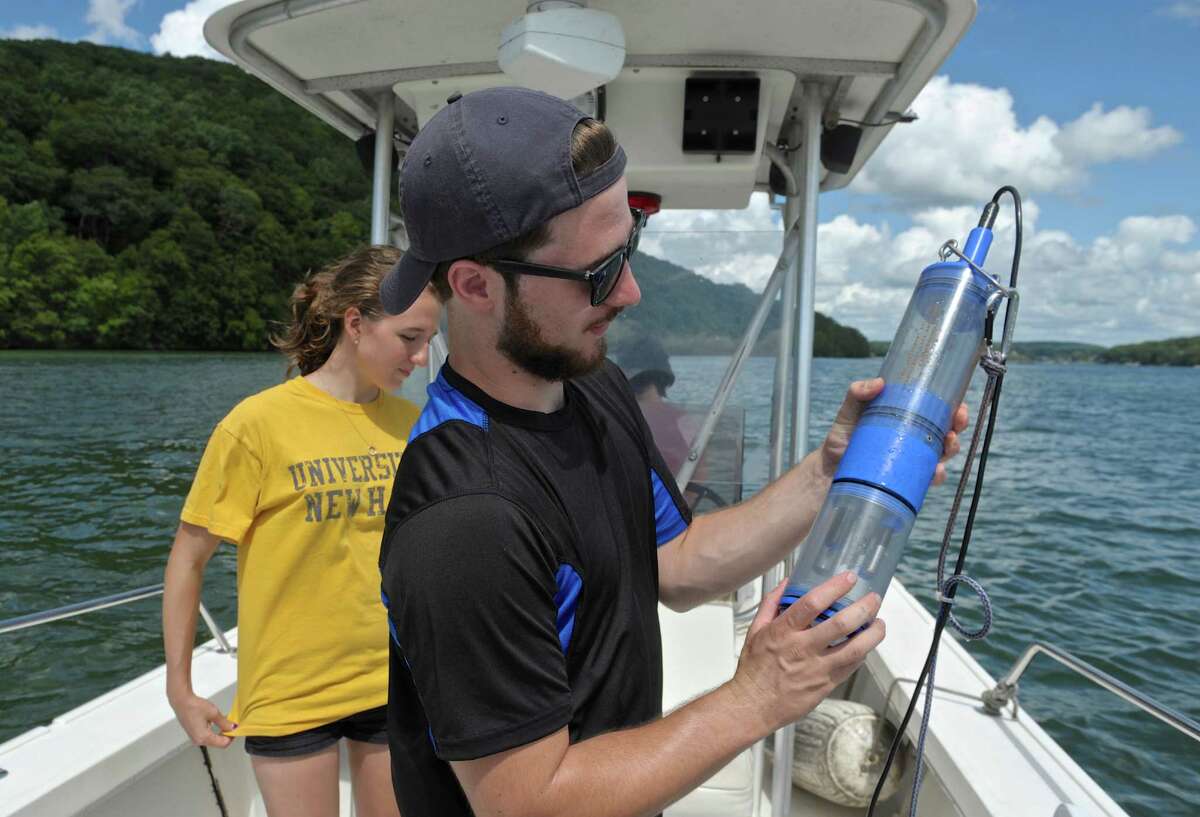 Christopher Gillotte, of Danbury, holds a water testing device while testing for blue-green algae in Candlewood Lake on Thursday. Gillotte is an intern with the New Fairfield health department. Samantha Doyle, an intern with the Candlewood Lake Authority, assists Gillotte.