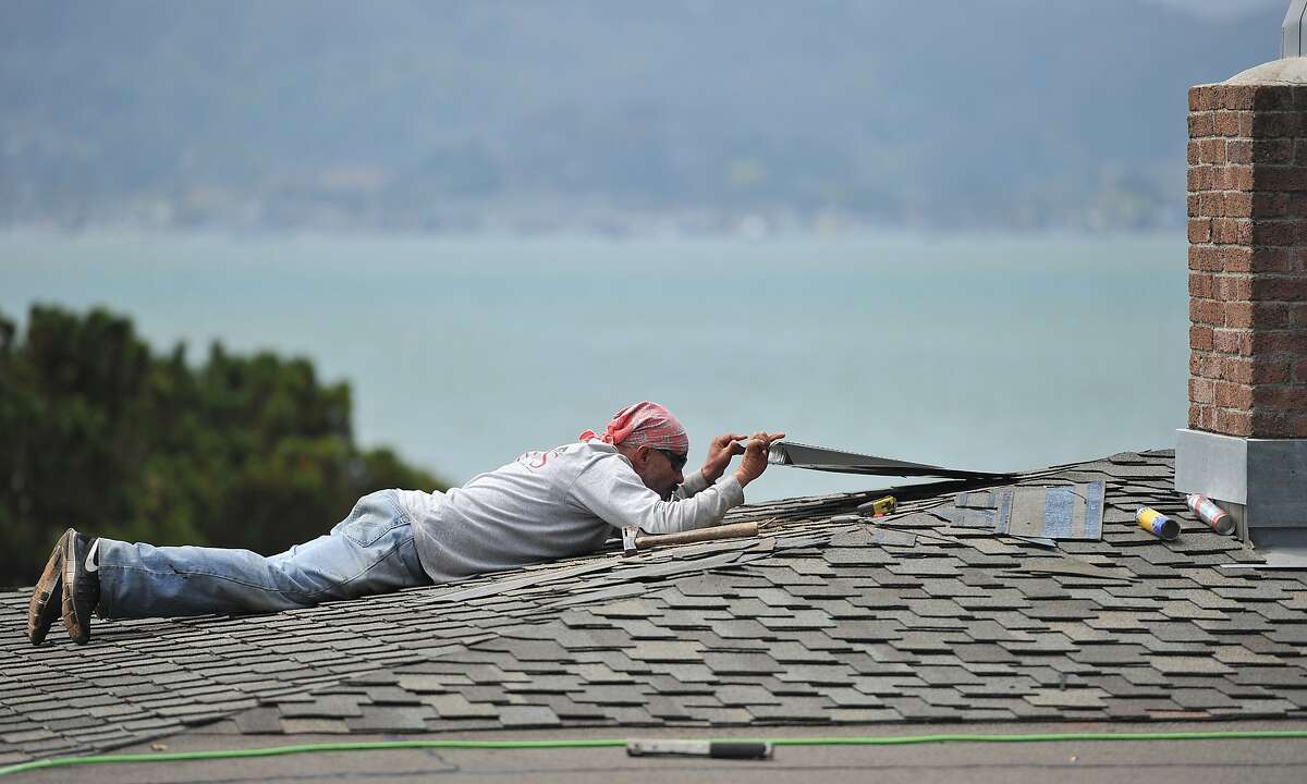 Pedro Carreno of ARS Roofing works on a home in Tiburon, California on Thursday, August 20, 2015. The U.S. Climate Prediction Center has said they expect rain soon, sending homeowners scrambling to finish repairs ahead of the weather. (JOSH EDELSON / SPECIAL TO THE CHRONICLE)