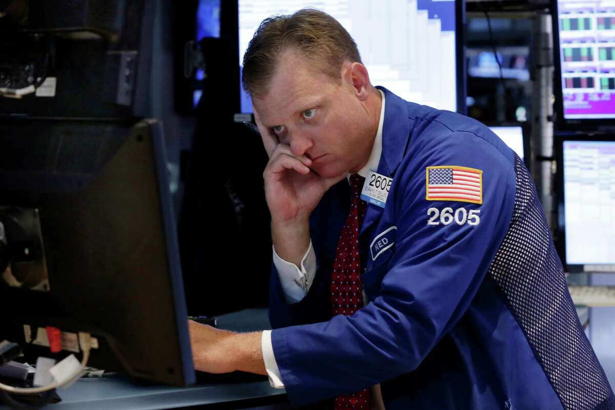 A specialist works on the floor of the New York Stock Exchange on Thursday as the Dow slides 358 points.