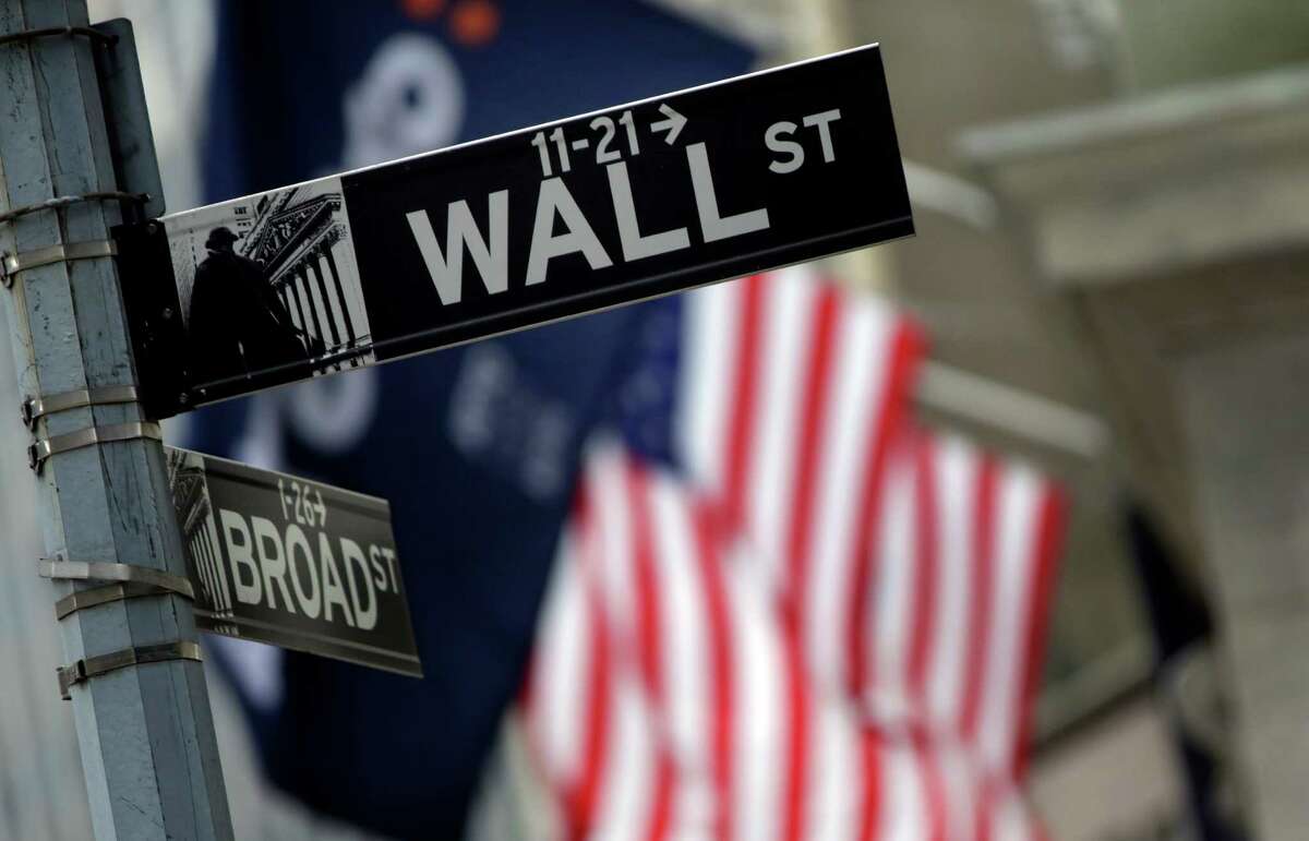 FILE - This Oct. 2, 2014 file photo shows a Wall Street sign adjacent to the New York Stock Exchange, in New York. A fresh sell-off of Chinese shares prompted renewed jitters across global markets on Thursday, Aug. 20, 2015. (AP Photo/Richard Drew, File)