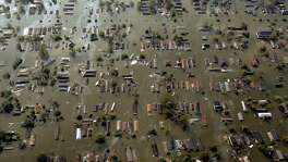 ** FILE ** Water surrounds homes just east of downtown New Orleans the day after Hurricane Katrina made landfall, in this Aug. 30, 2005 file photo.  Despite a flurry of promises, Congress repeatedly has put off  unpopular steps that experts say are necessary to fix the main flood insurance program. Hurricanes Katrina and Rita, back-to-back storms in 2005, shattered any notion the program was self-sustaining, threw the program roughly $20 billion into debt and called attention to its structural flaws.